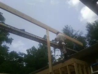Carpenter setting a ridge beam over a new addition frame — Ice Dam Removal by Roofing Brothers in Custer